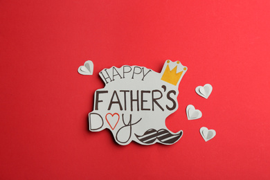 Greeting card with phrase HAPPY FATHER'S DAY on red background, flat lay