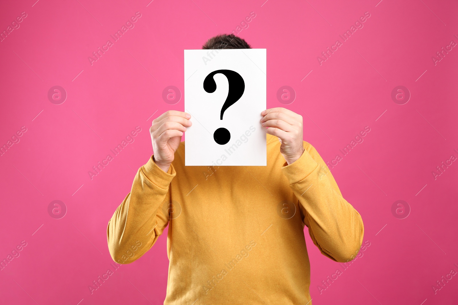 Photo of Man holding paper with question mark on pink background