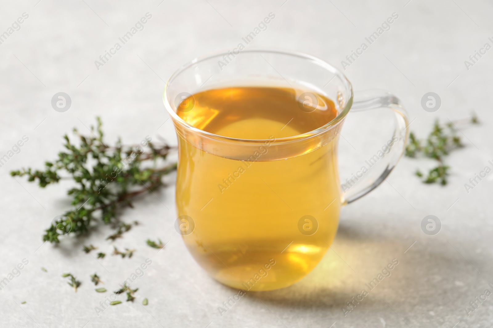 Photo of Aromatic herbal tea with thyme on light table