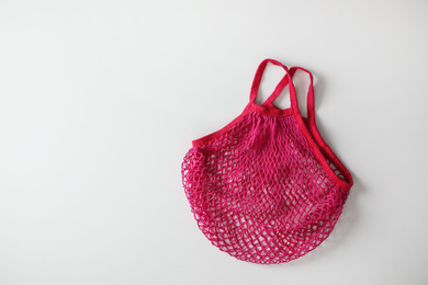 Empty pink net bag on white background, top view. Space for text