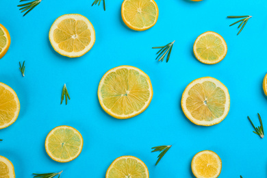 Photo of Lemonade layout with juicy lemon slices and rosemary on blue background, top view