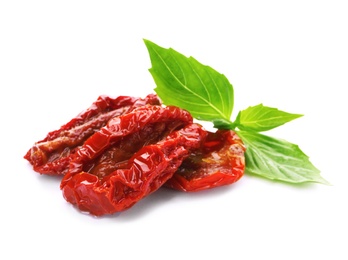 Photo of Tasty sun dried tomatoes with green leaves on white background