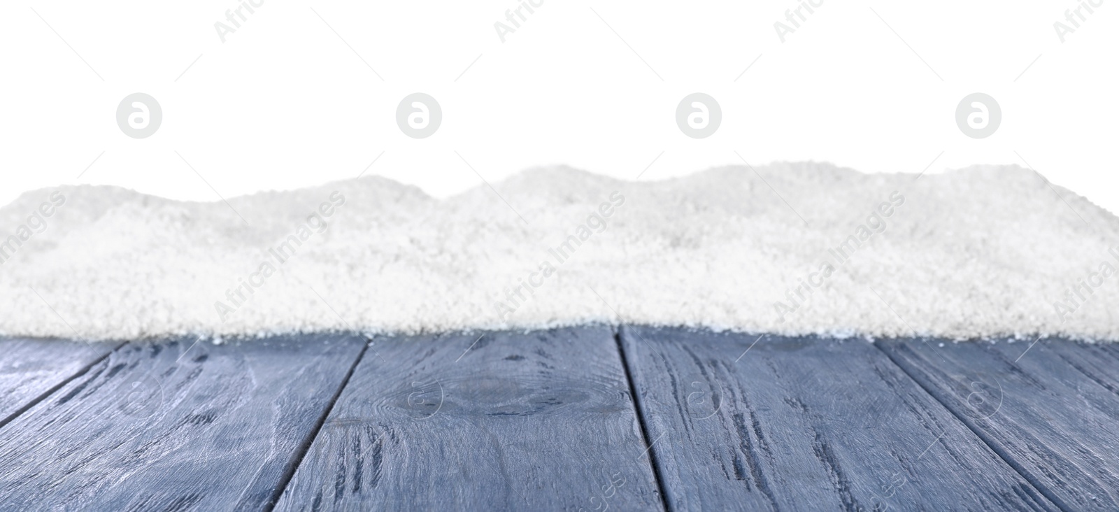 Photo of Heap of snow on blue wooden surface against white background