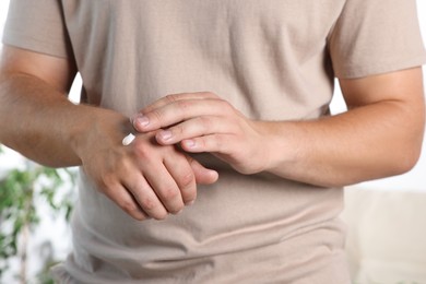 Photo of Man applying hand cream at home, closeup