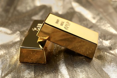 Photo of Two gold bars on shiny fabric, closeup