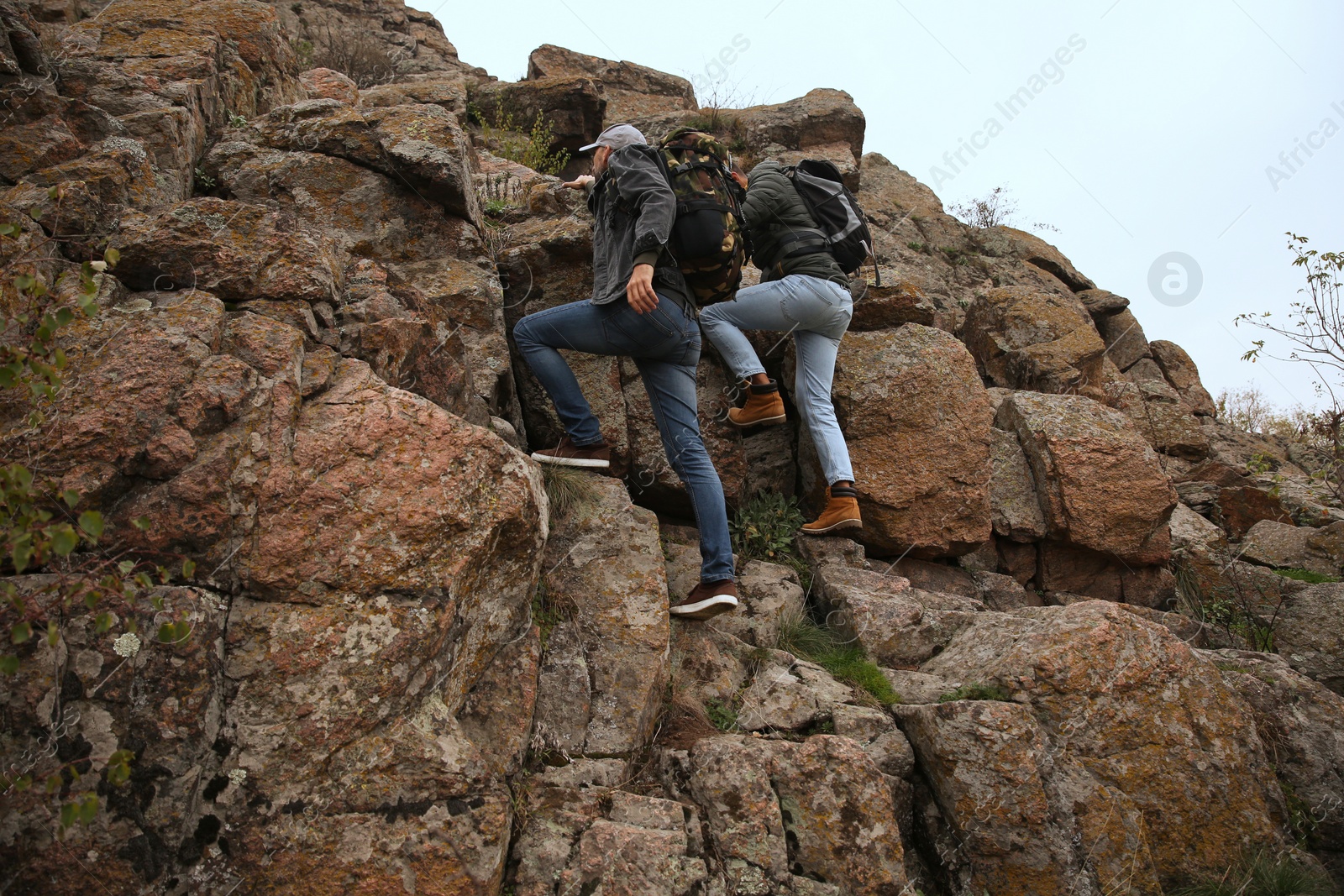 Photo of Hikers with backpacks climbing up mountains on autumn day