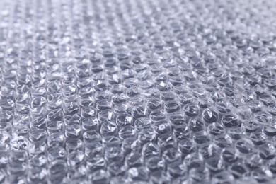 Photo of Transparent bubble wrap on black background, closeup