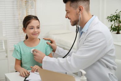 Pediatrician examining little girl in office at hospital