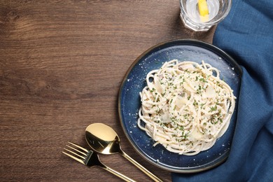 Photo of Delicious pasta with mushroom sauce and parmesan cheese served on wooden table, flat lay. Space for text
