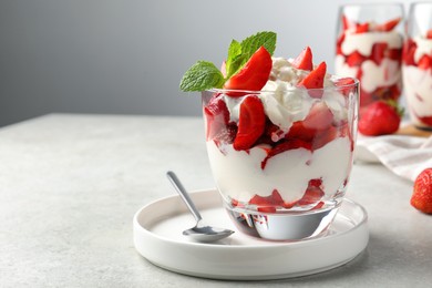 Delicious strawberries with whipped cream served on light grey table. Space for text