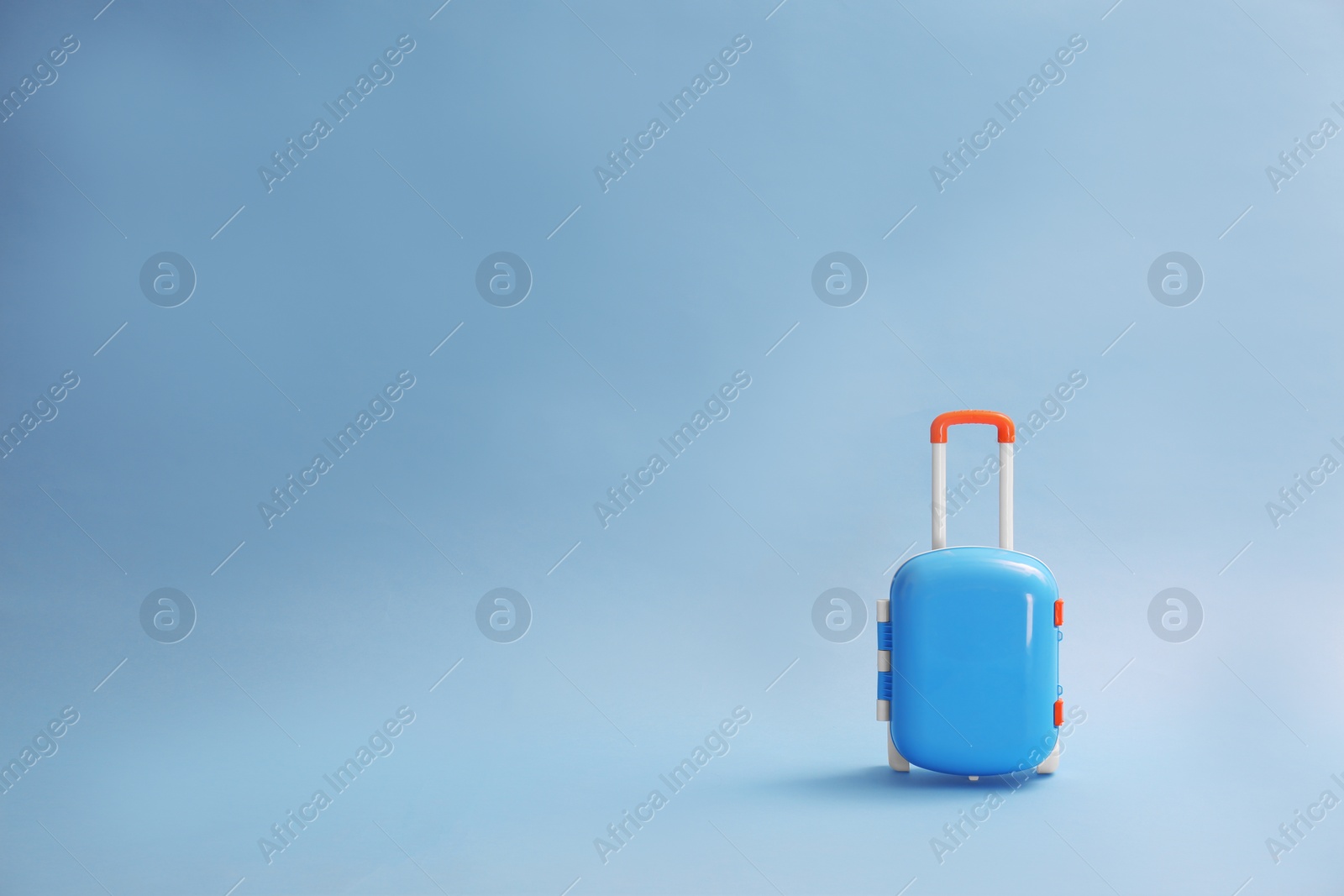 Photo of Stylish child suitcase on blue background, space for text