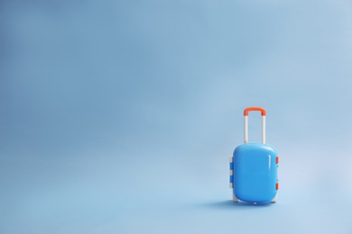 Stylish child suitcase on blue background, space for text