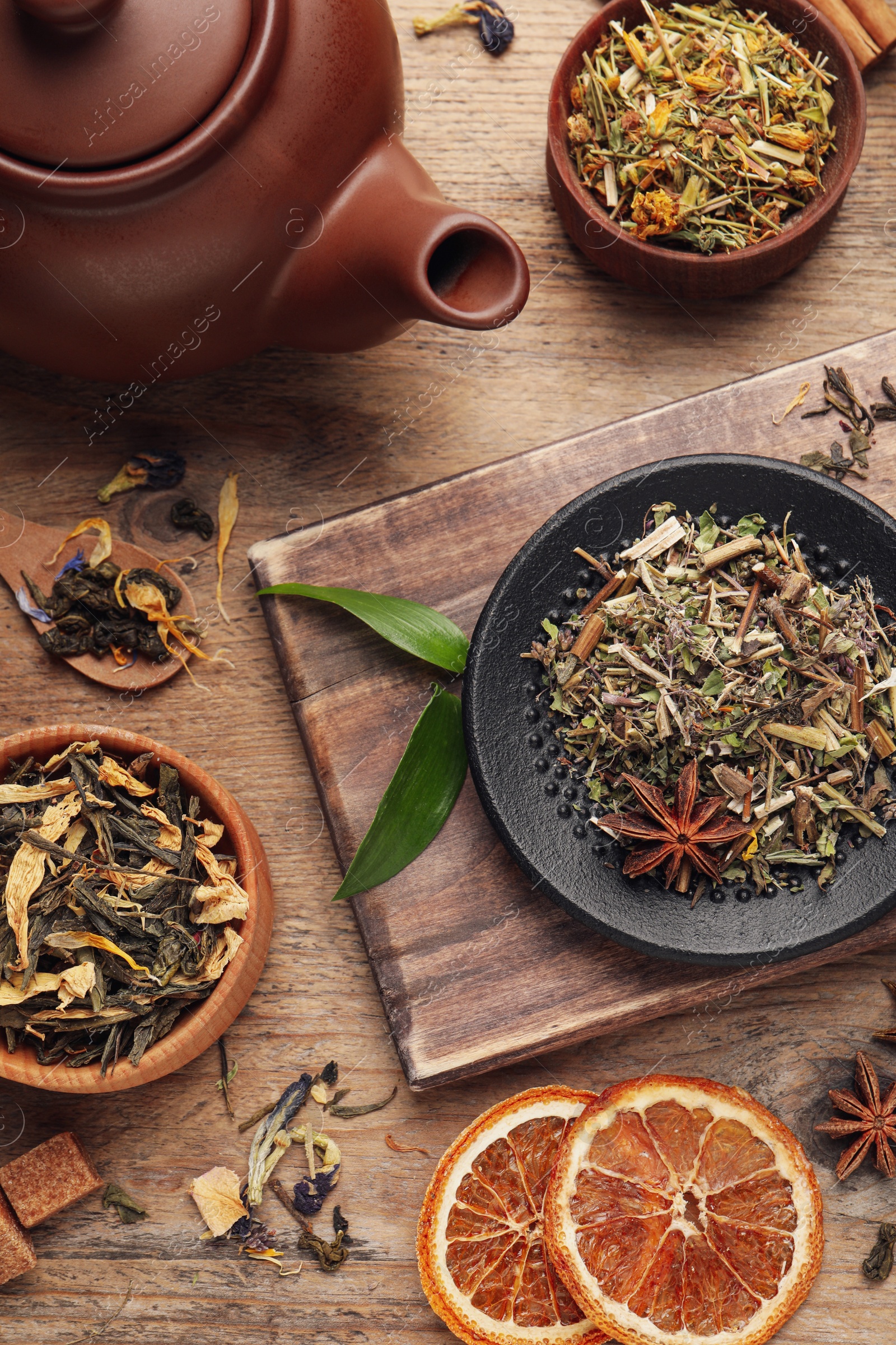 Photo of Flat lay composition with different dry teas on wooden table