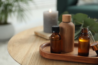 Aromatherapy. Bottles of essential oil on wooden table, space for text