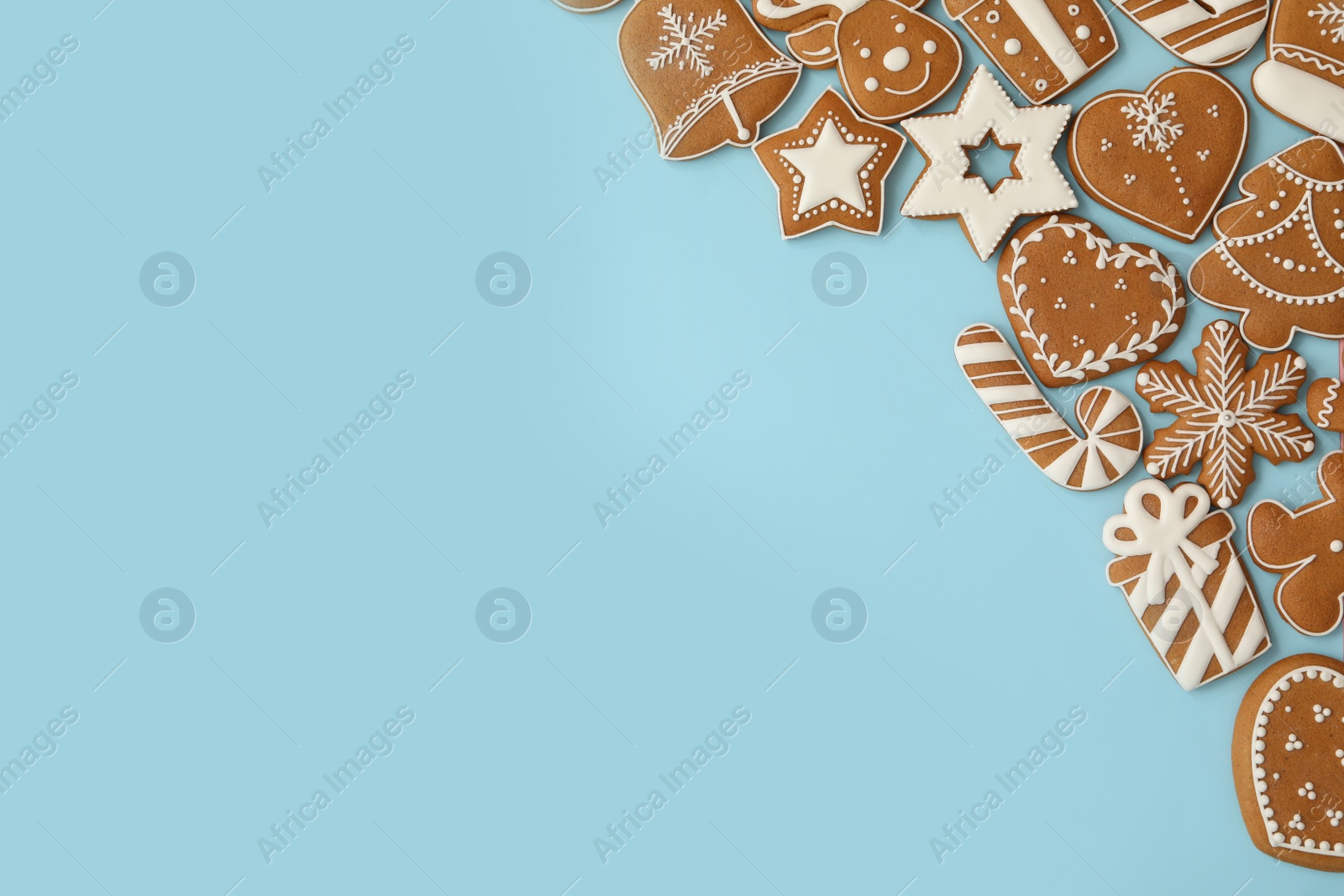 Photo of Different Christmas gingerbread cookies on light blue background, flat lay. Space for text