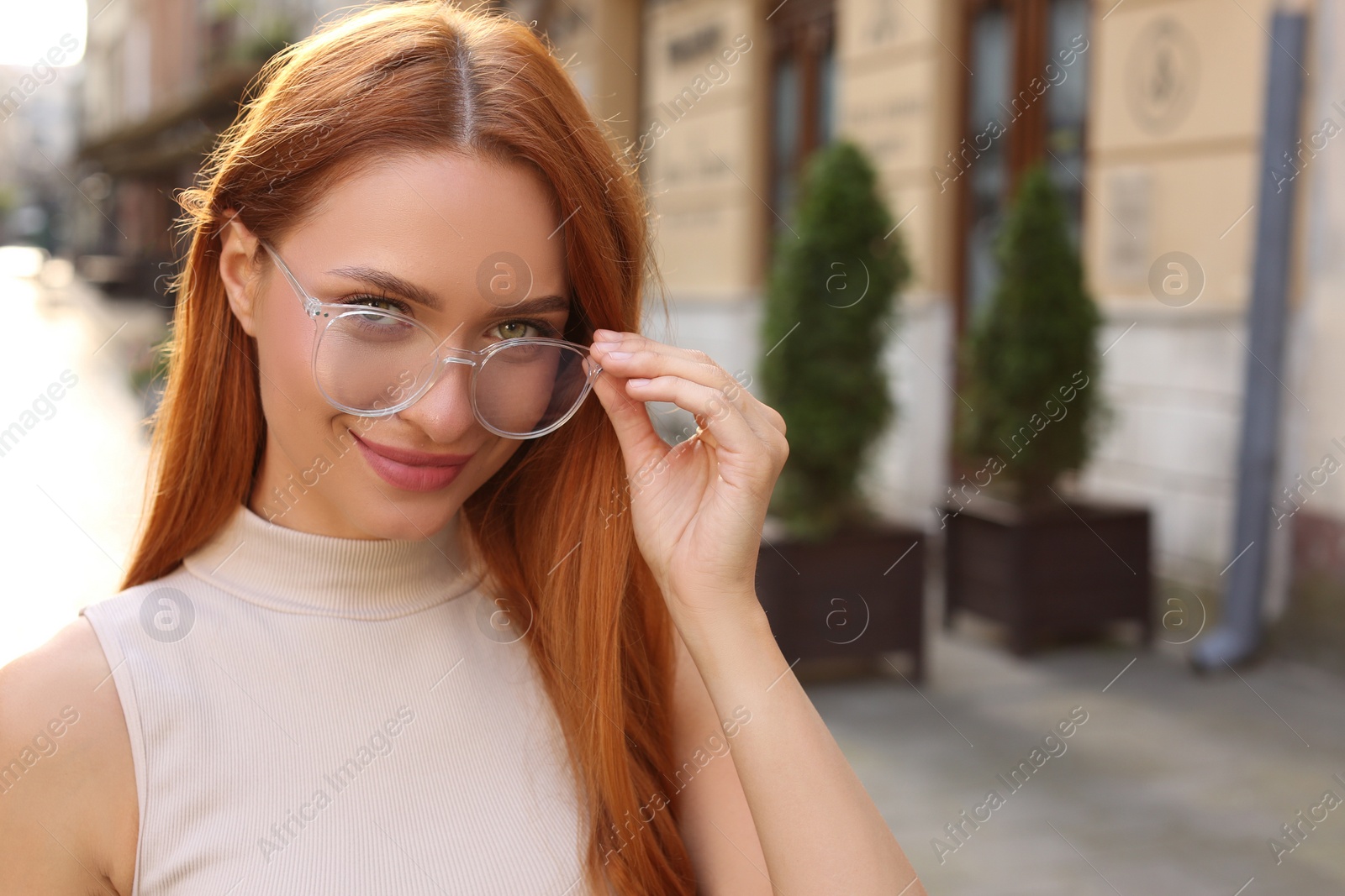 Photo of Portrait of beautiful woman in glasses outdoors, space for text