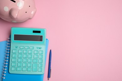 Calculator, piggy bank, notebooks and pen on pink background, flat lay with space for text