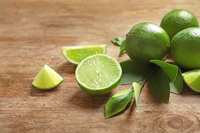 Photo of Fresh ripe limes on wooden table. Citrus fruit