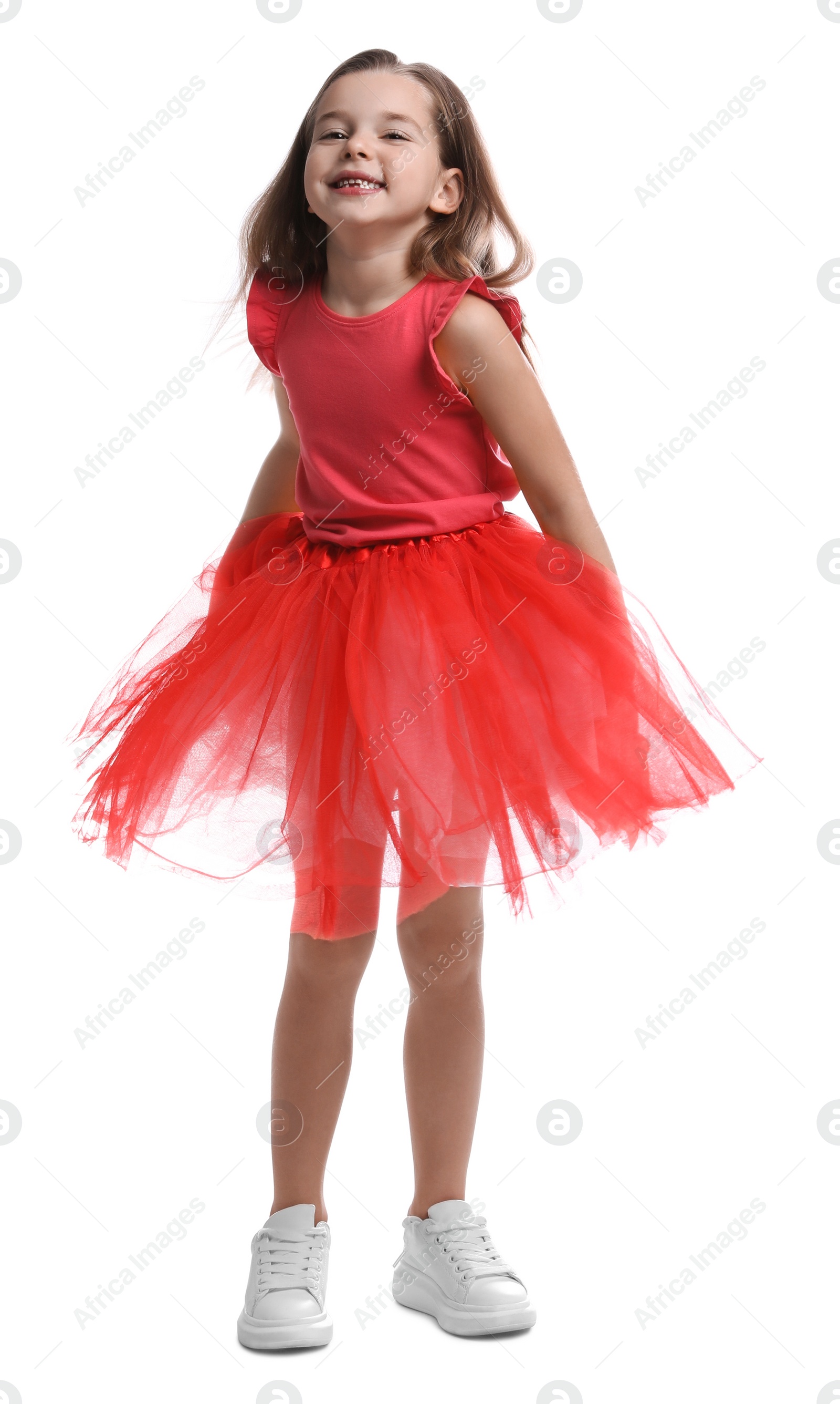 Photo of Cute little girl in tutu skirt dancing on white background