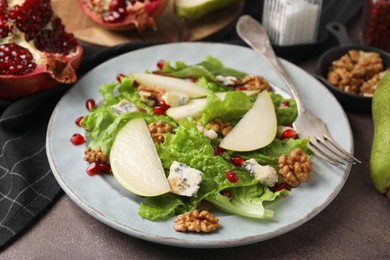 Photo of Delicious pear salad on dark textured table, closeup