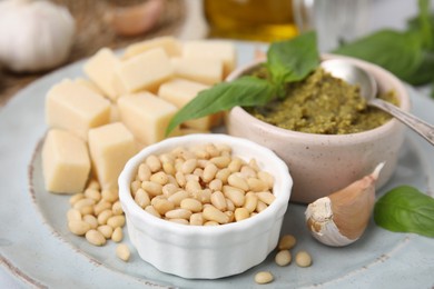 Photo of Tasty pesto sauce and ingredients on plate, closeup
