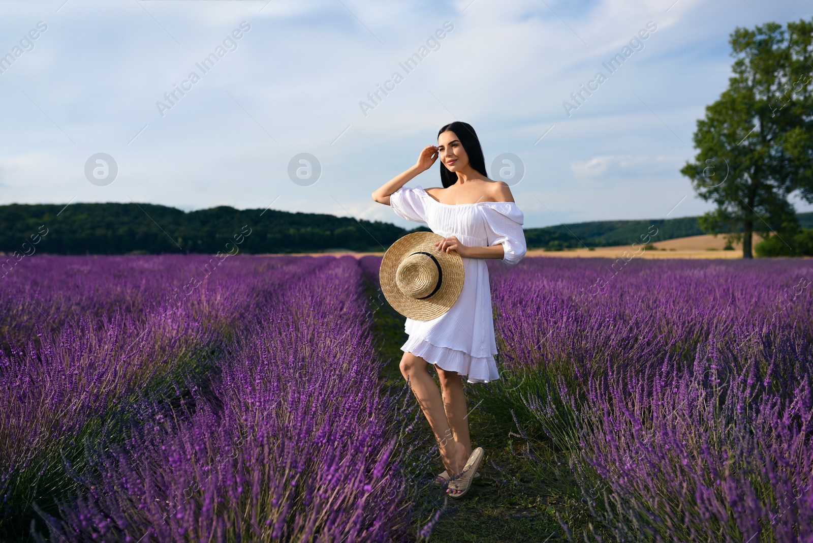 Photo of Beautiful young woman walking in lavender field