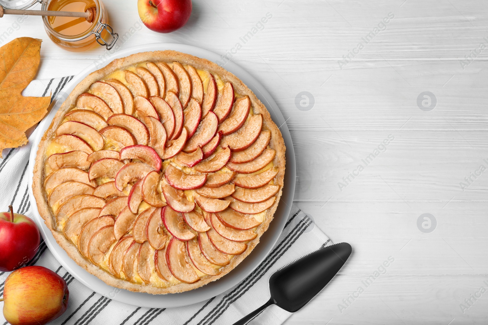 Photo of Flat lay composition with tasty apple pie on white wooden table, space for text