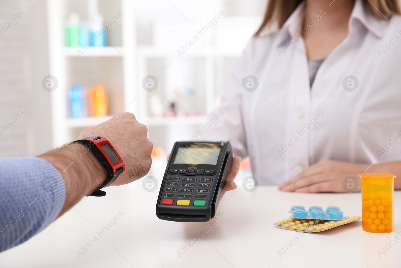 Photo of Man using terminal for contactless payment with smart watch in pharmacy, closeup. Space for text