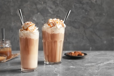 Photo of Glasses with delicious caramel frappe on table