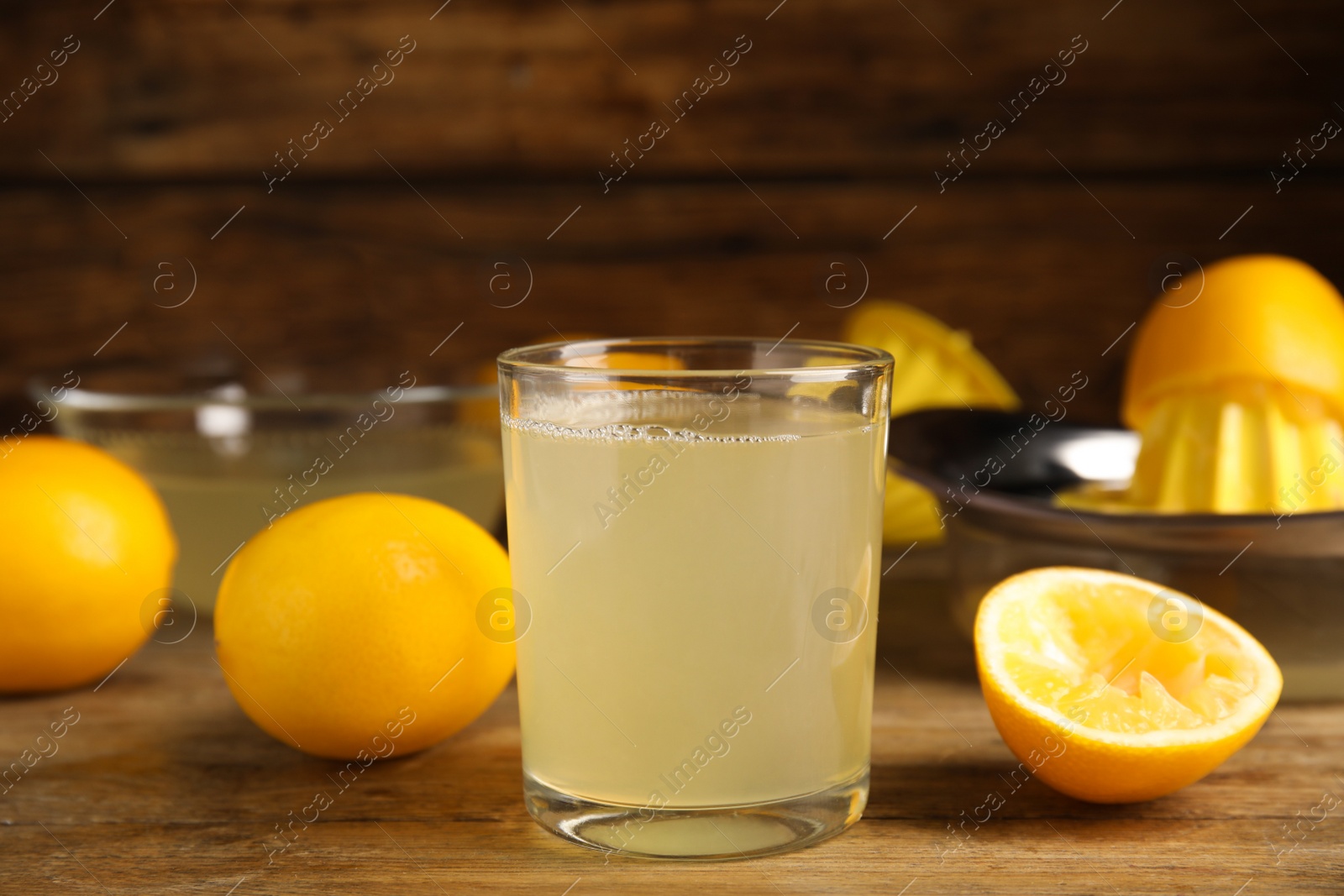 Photo of Freshly squeezed lemon juice on wooden table