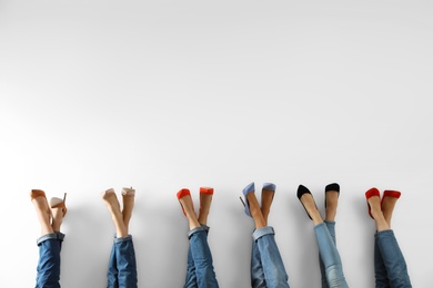 Young women in elegant shoes on white background, closeup