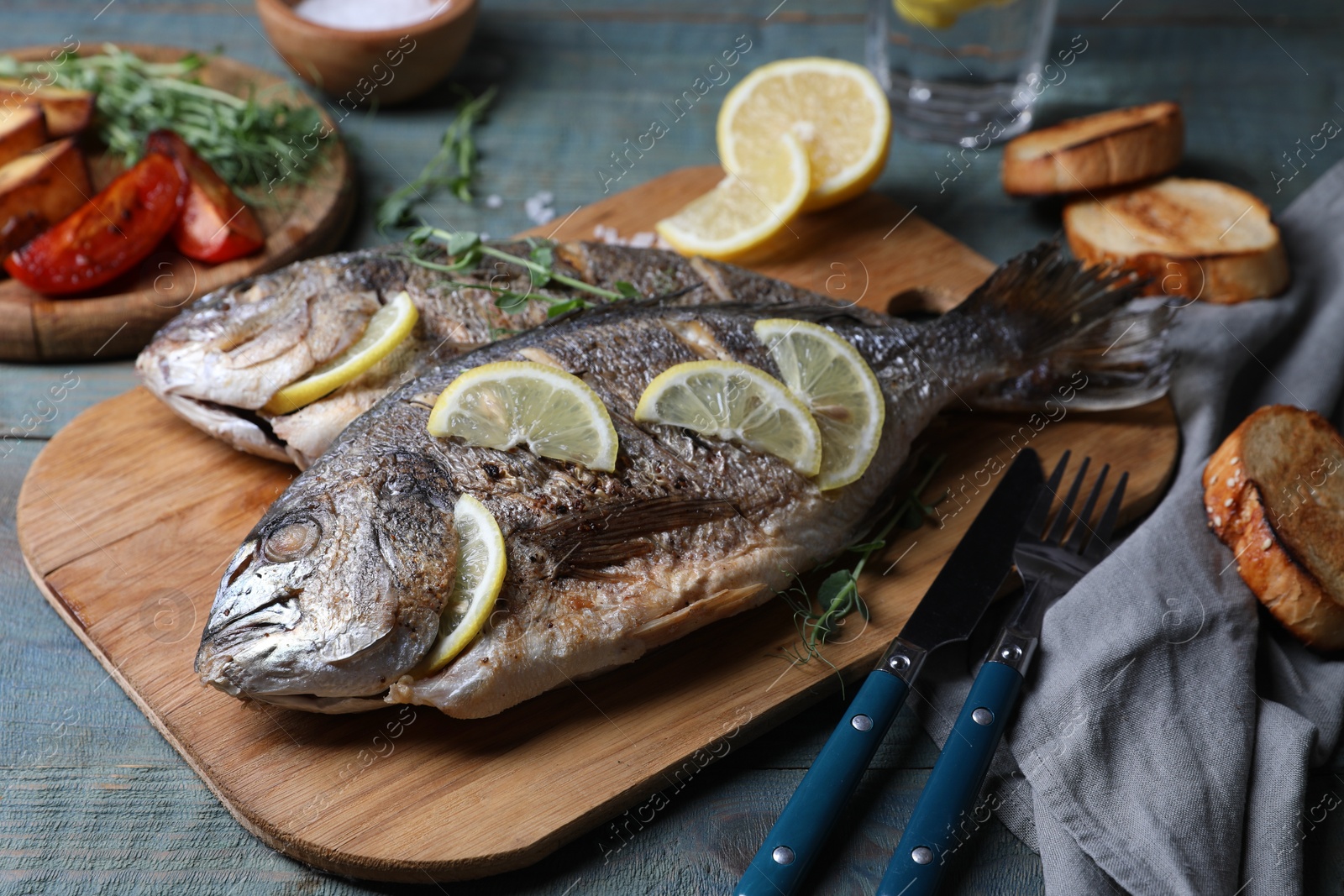 Photo of Delicious baked fish served on wooden rustic table. Seafood