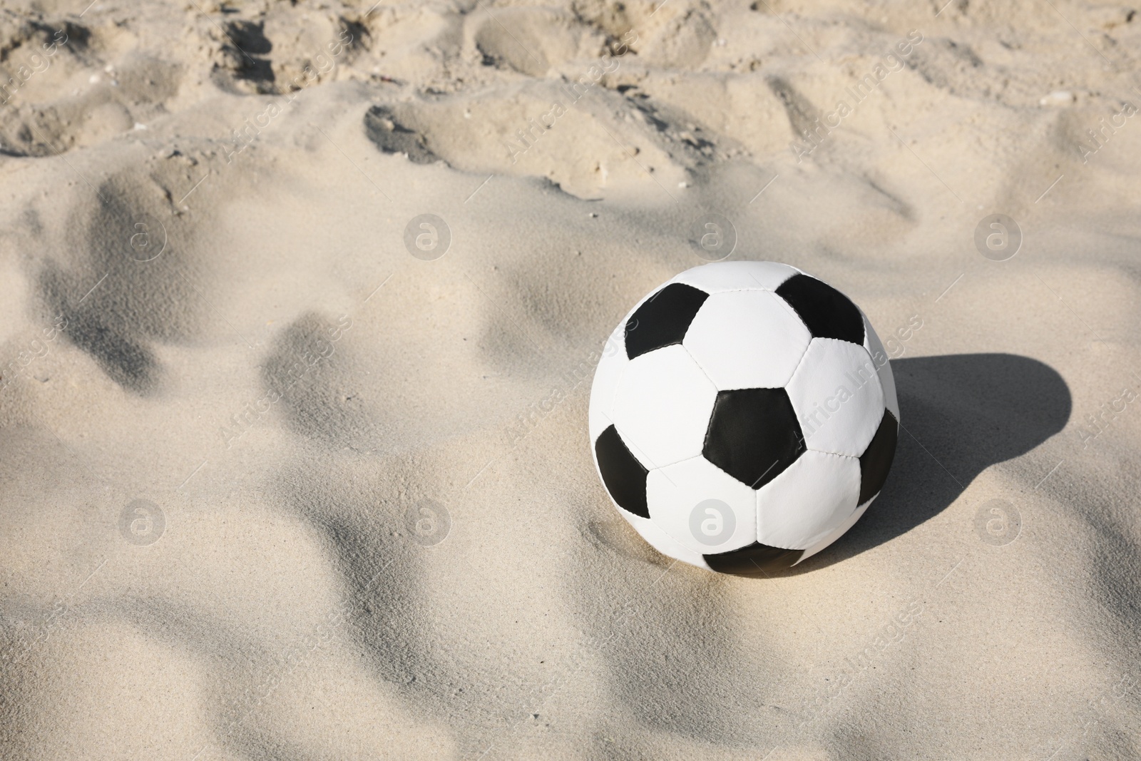 Photo of Soccer ball on sand, space for text. Football equipment