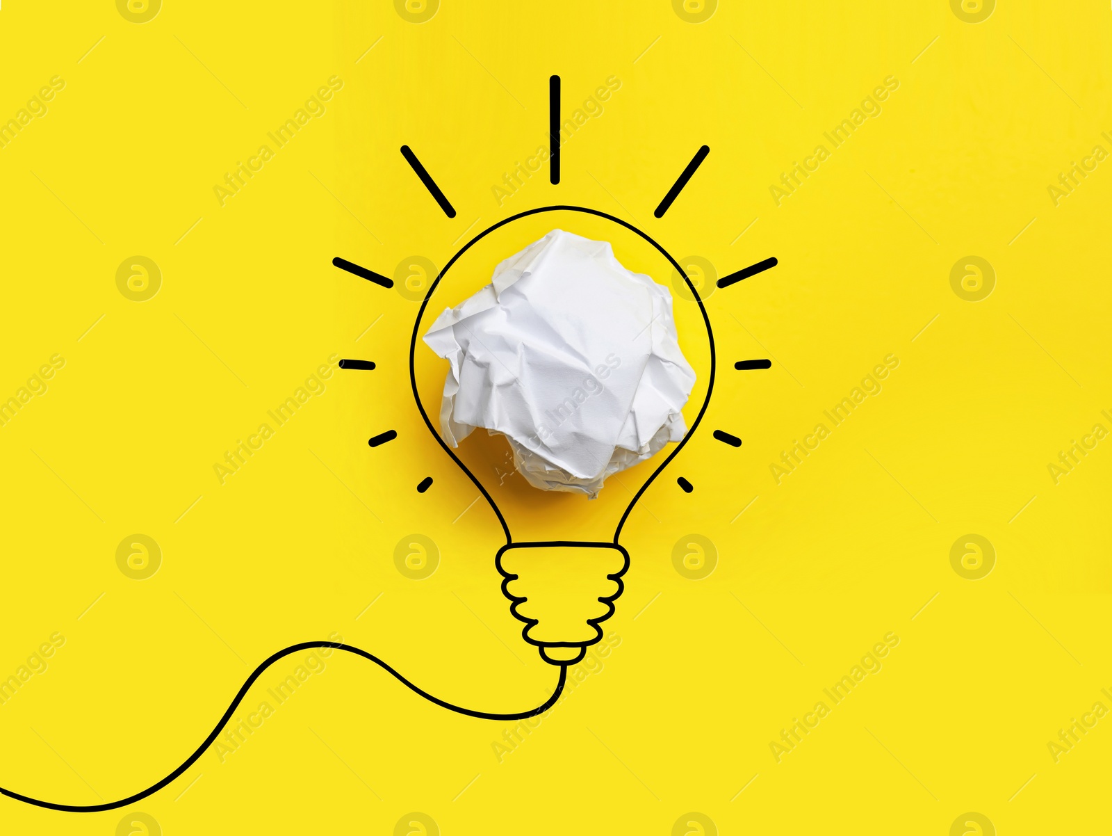 Image of Idea. Illustration of light bulb around crumpled paper ball on yellow background, top view