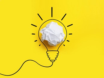 Image of Idea. Illustration of light bulb around crumpled paper ball on yellow background, top view