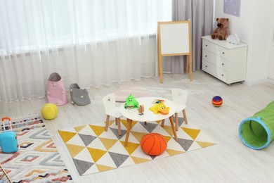 Photo of Child`s playroom with different toys and modern furniture. Stylish kindergarten interior