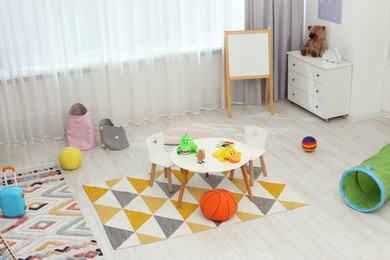 Child`s playroom with different toys and modern furniture. Stylish kindergarten interior