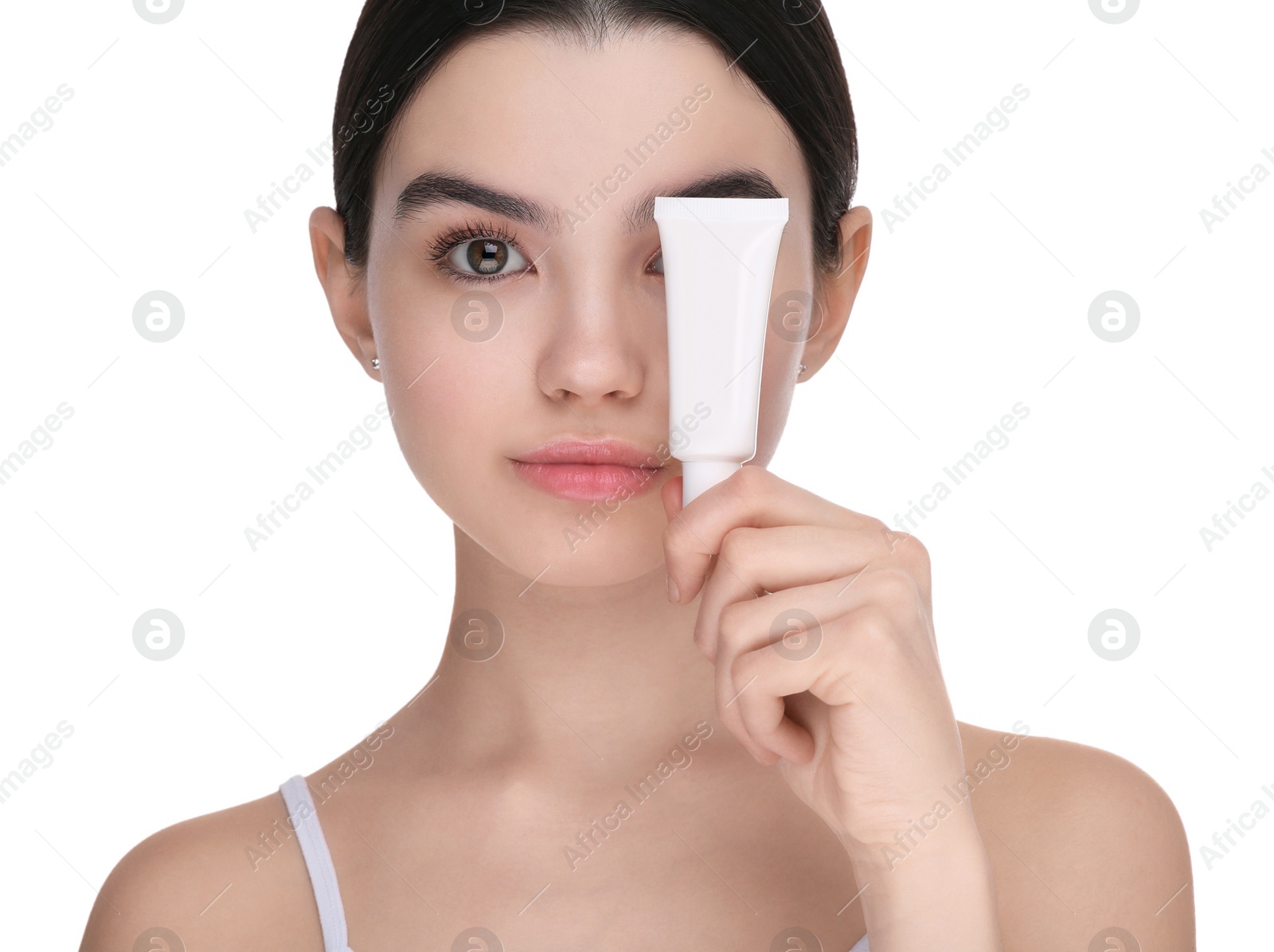 Photo of Teenage girl holding tube of foundation on white background