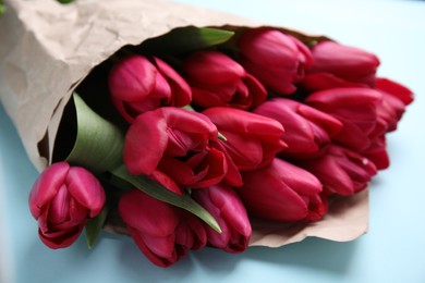 Photo of Bouquet of beautiful tulips on light blue background, closeup