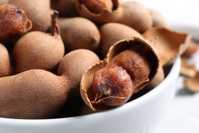 Delicious ripe tamarinds in ceramic bowl, closeup