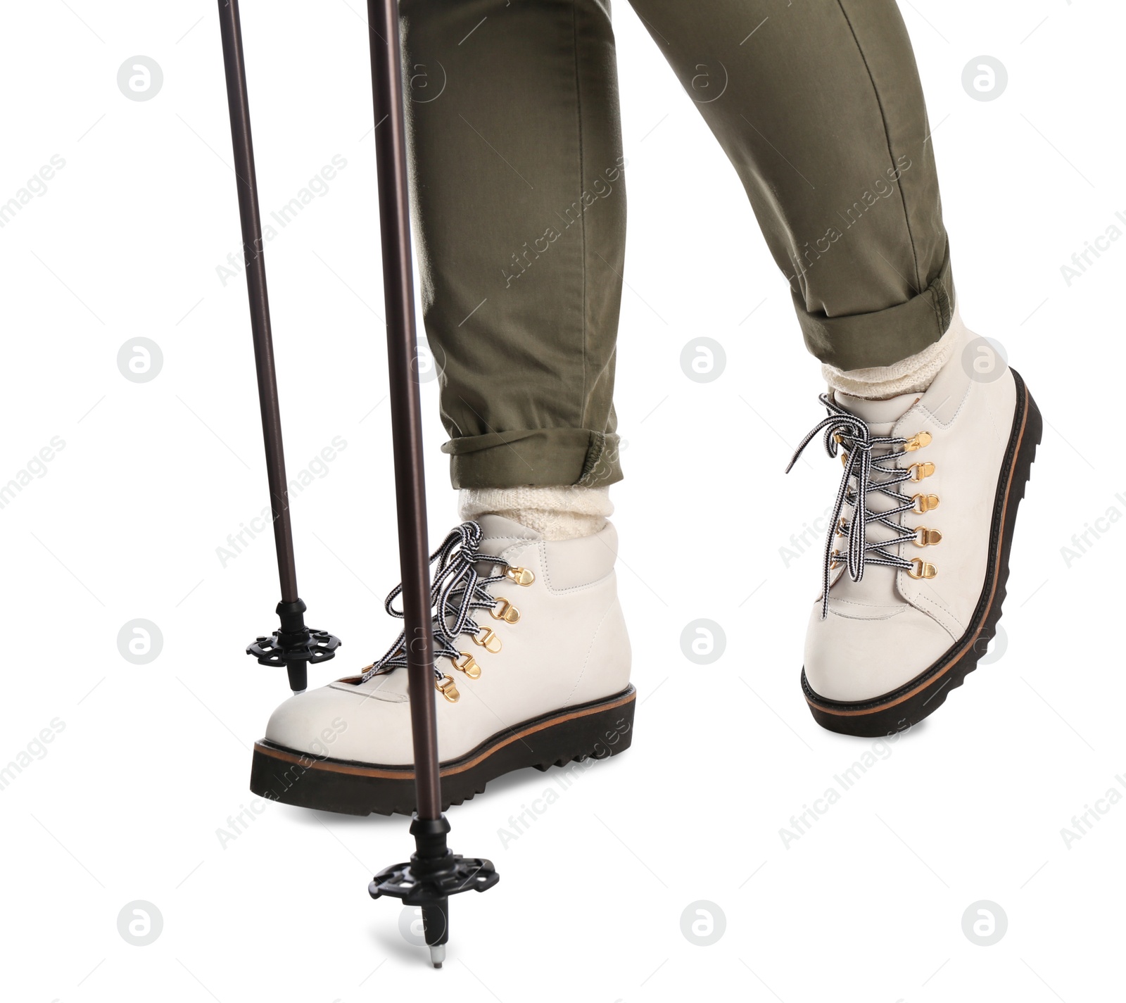 Photo of Woman wearing stylish hiking boots with trekking poles on white background, closeup