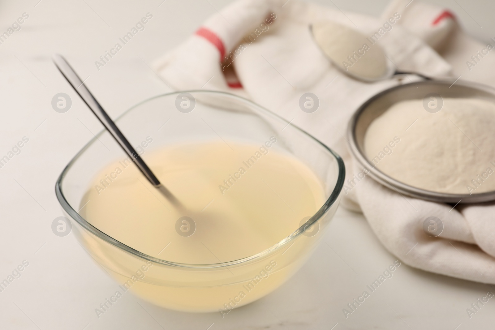 Photo of Agar-agar jelly and powder on white marble table, closeup