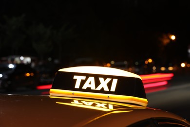 Photo of Taxi car with yellow sign on city street at night