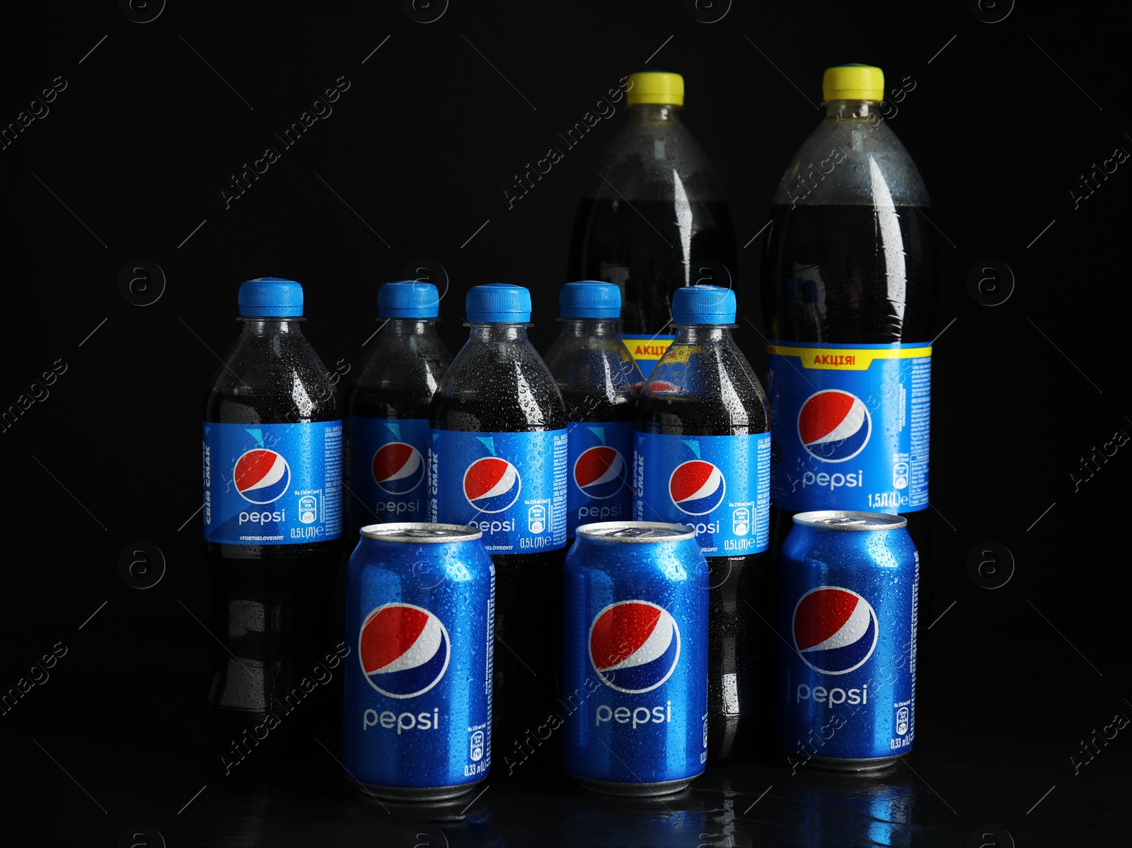 Photo of MYKOLAIV, UKRAINE - FEBRUARY 08, 2021: Cans and bottles of Pepsi on black background