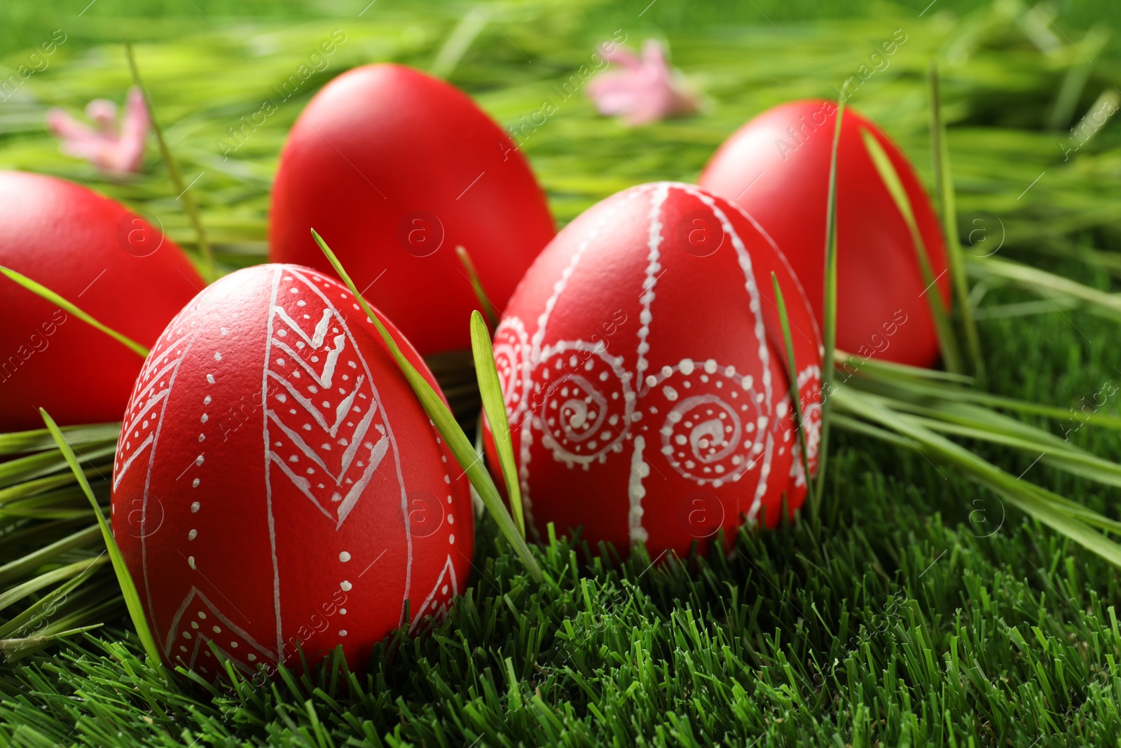 Photo of Red painted Easter eggs on green grass