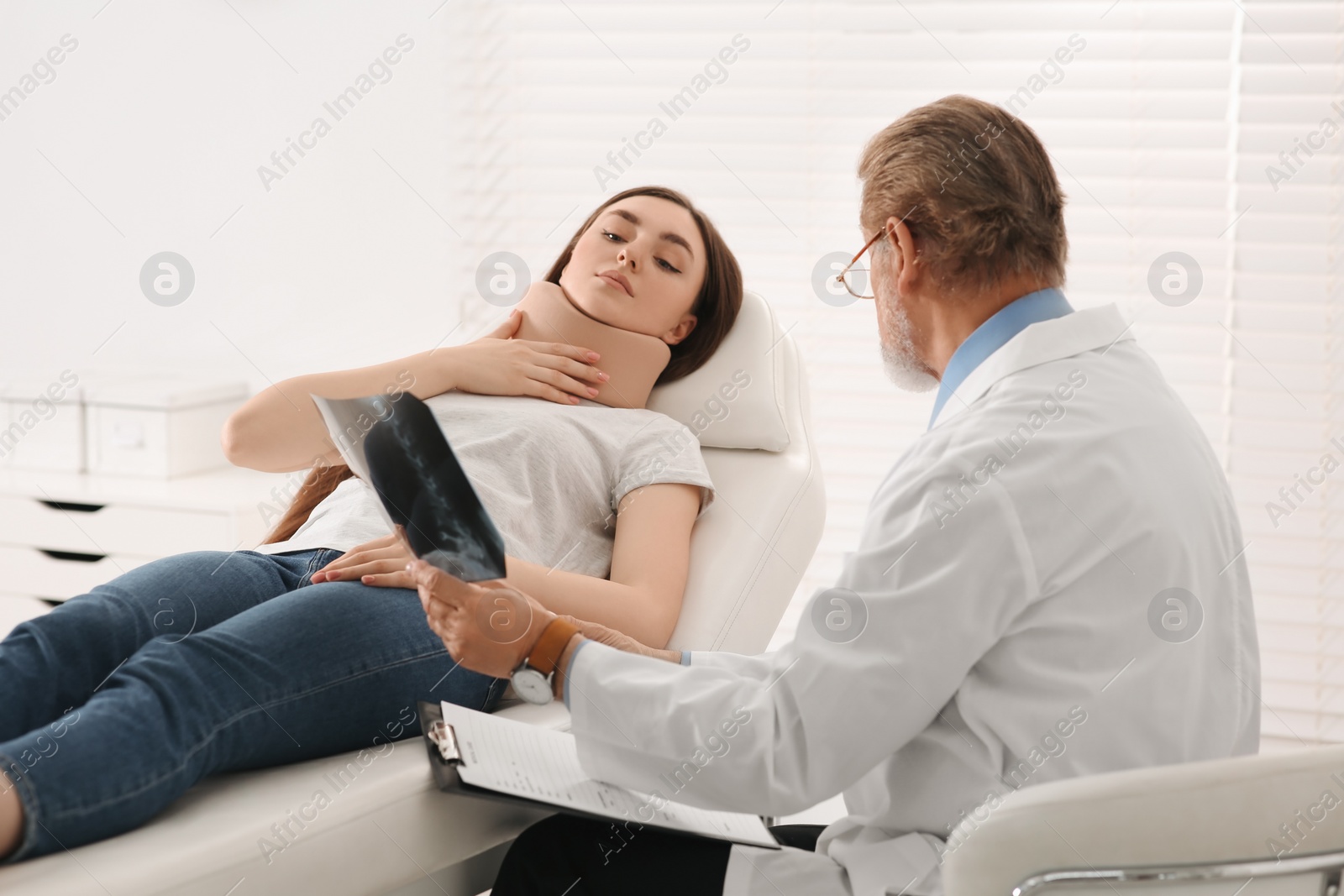 Photo of Orthopedist showing X-ray picture to patient in clinic