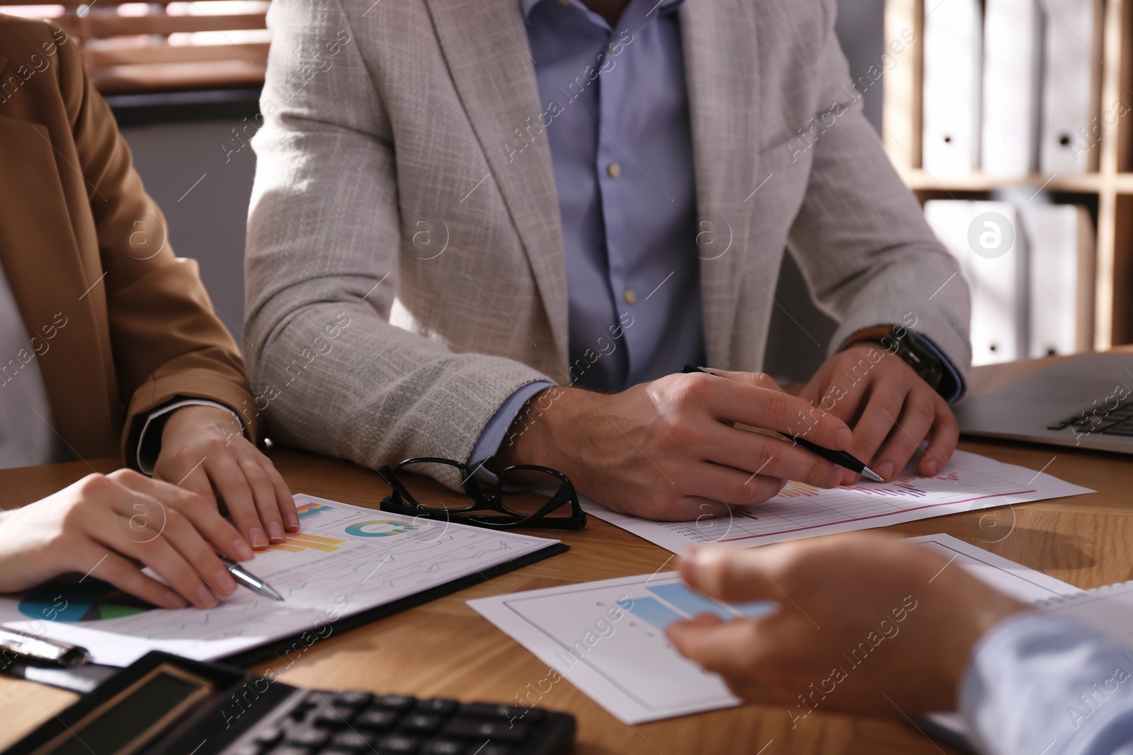 Photo of Business people working with documents at table in office, closeup. Investment analysis