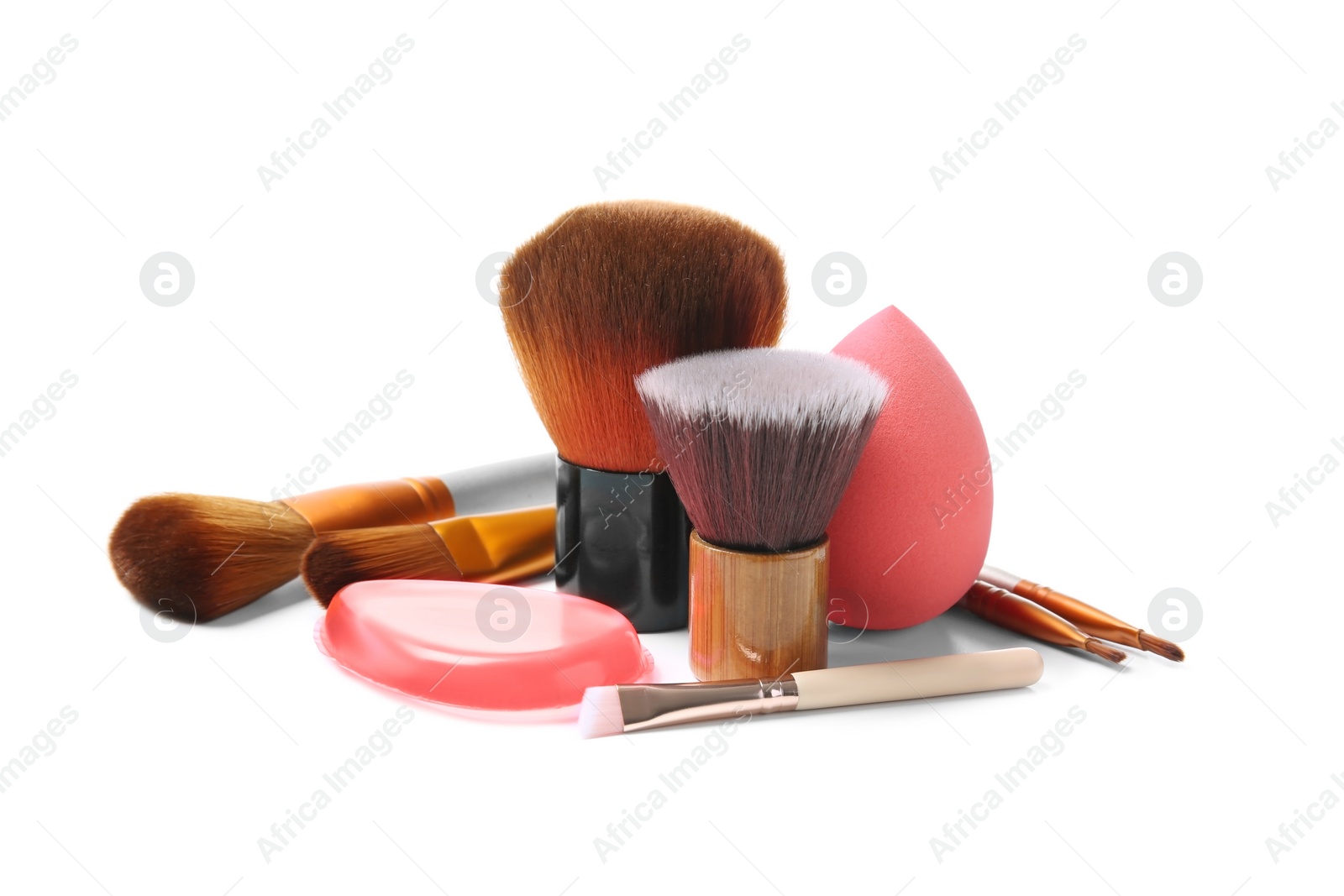 Photo of Makeup brushes and sponge of professional artist on white background