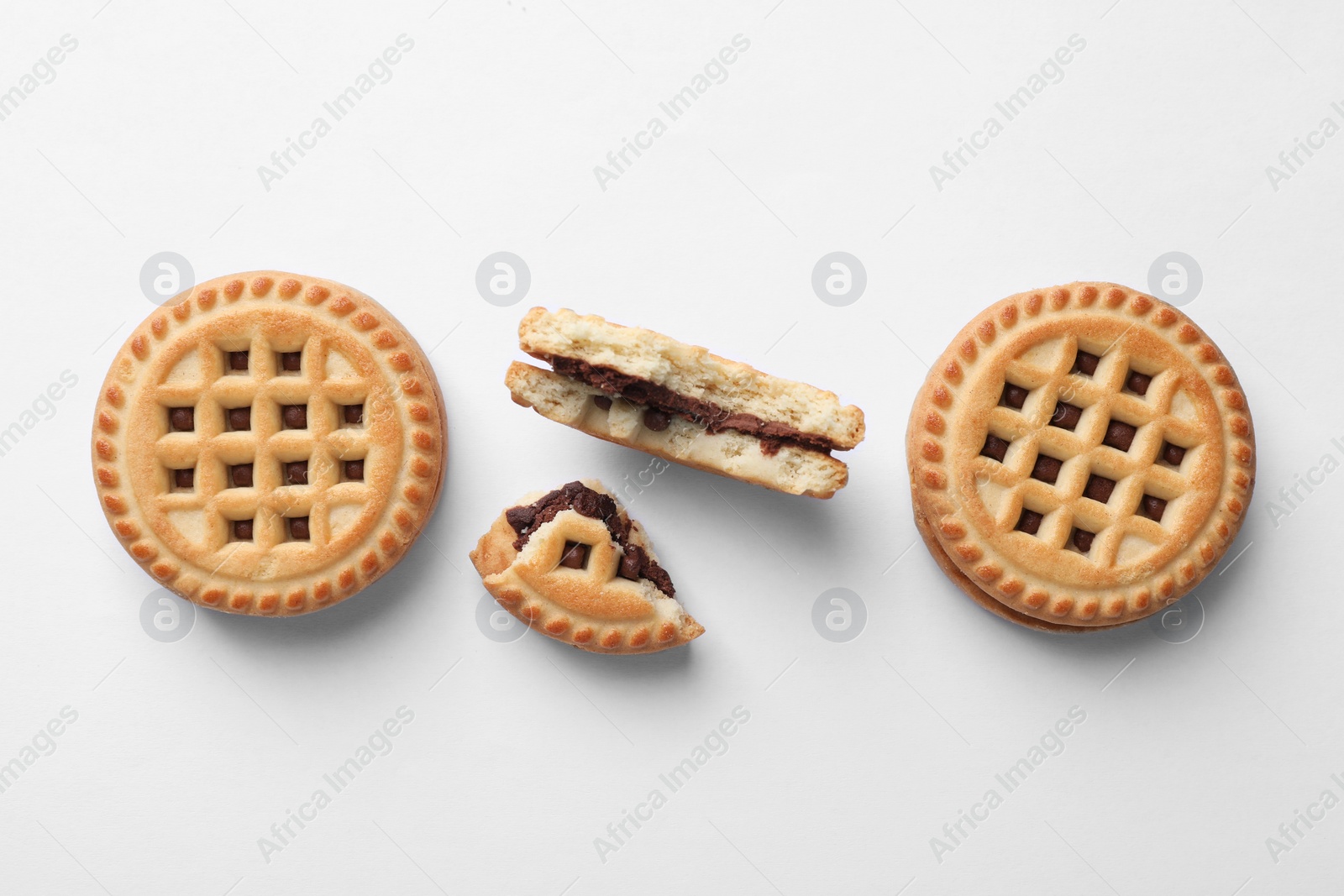 Photo of Tasty sandwich cookies with cream on white background, flat lay