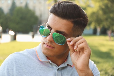 Photo of Handsome man wearing stylish sunglasses in park